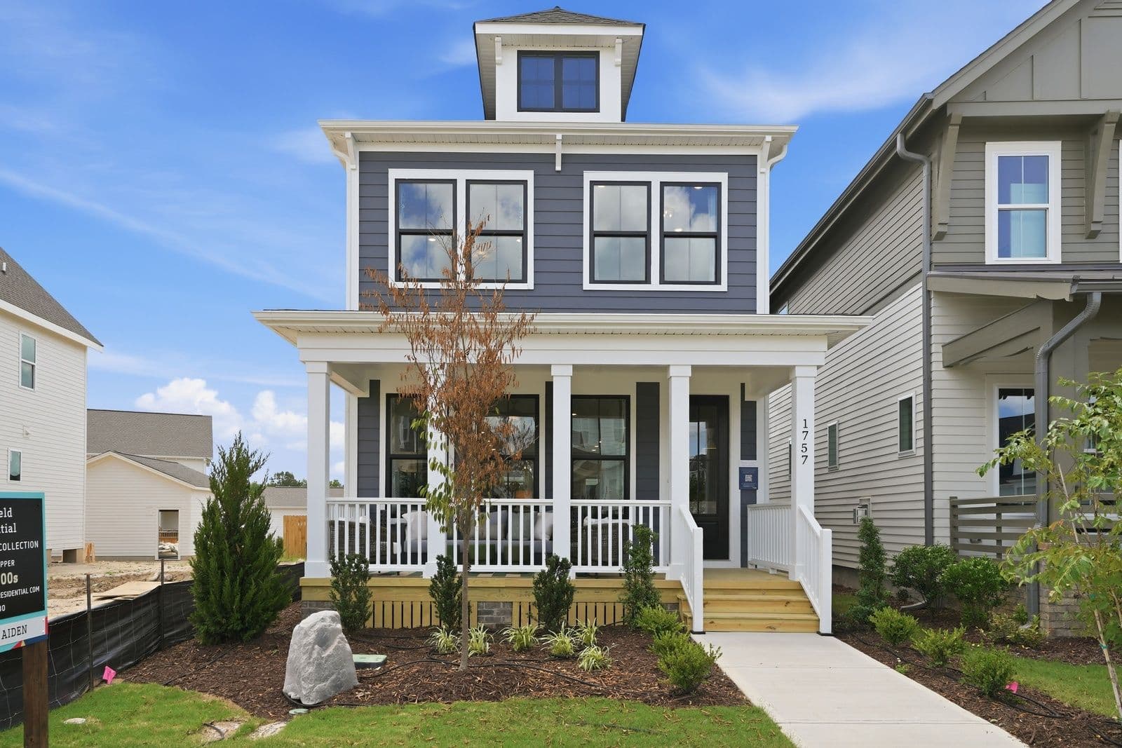 The Aiden Parade home at 1757 Piney Falls Drive, with a gray exterior, white front porch and blue sky